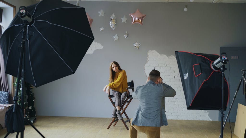 Photographer capturing a model in a professional studio setup with lighting.