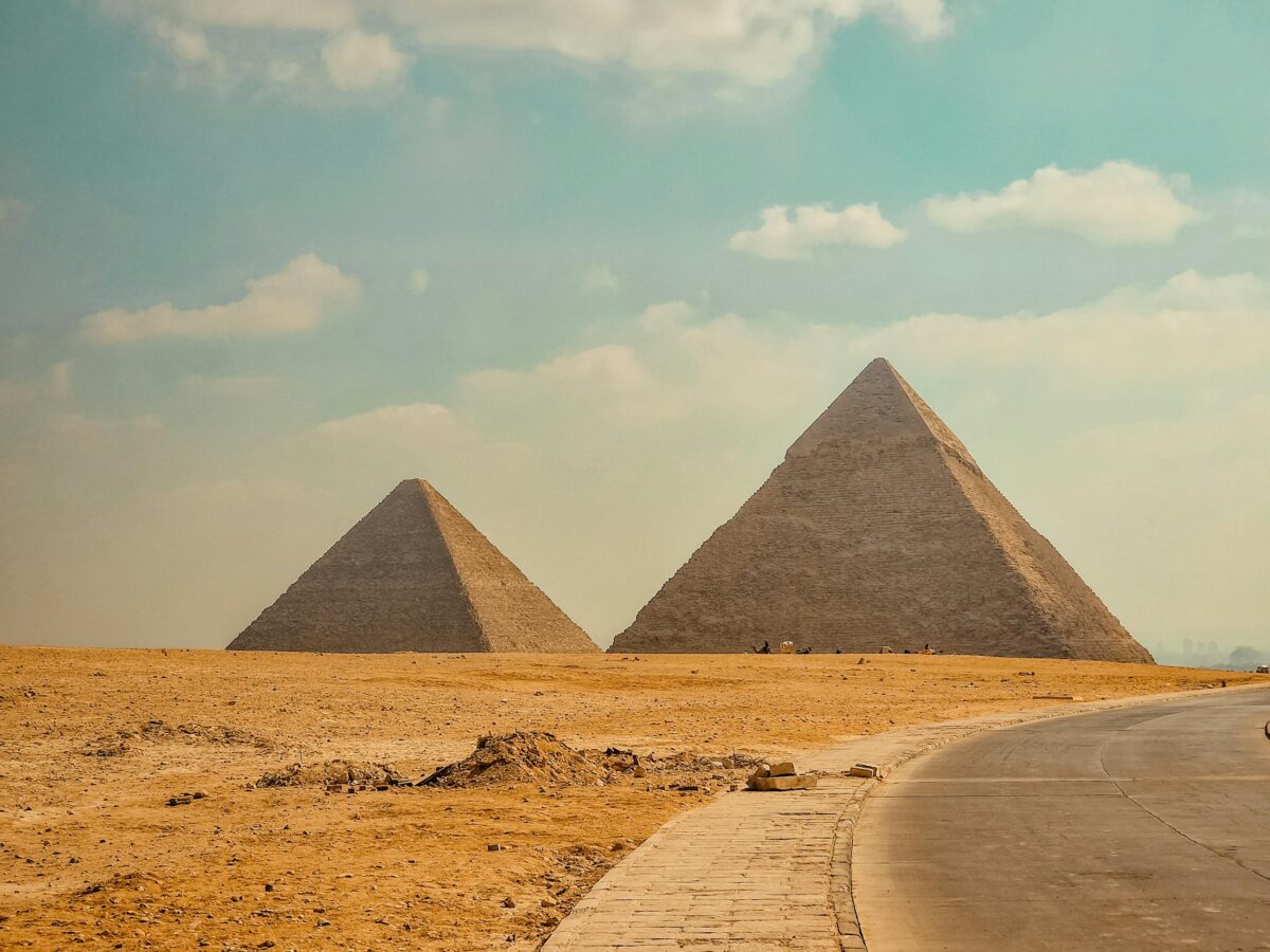 Stunning view of the Great Pyramids of Giza under a blue sky in Cairo, Egypt.